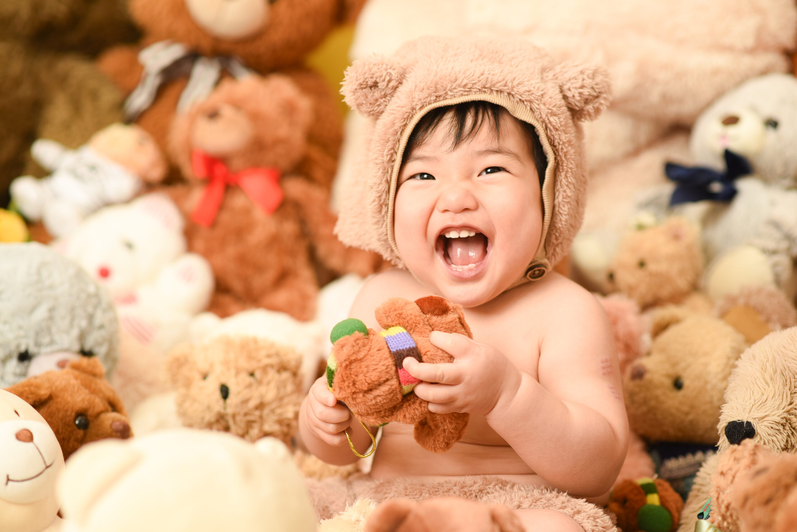 クマに囲まれる笑顔の赤ちゃん